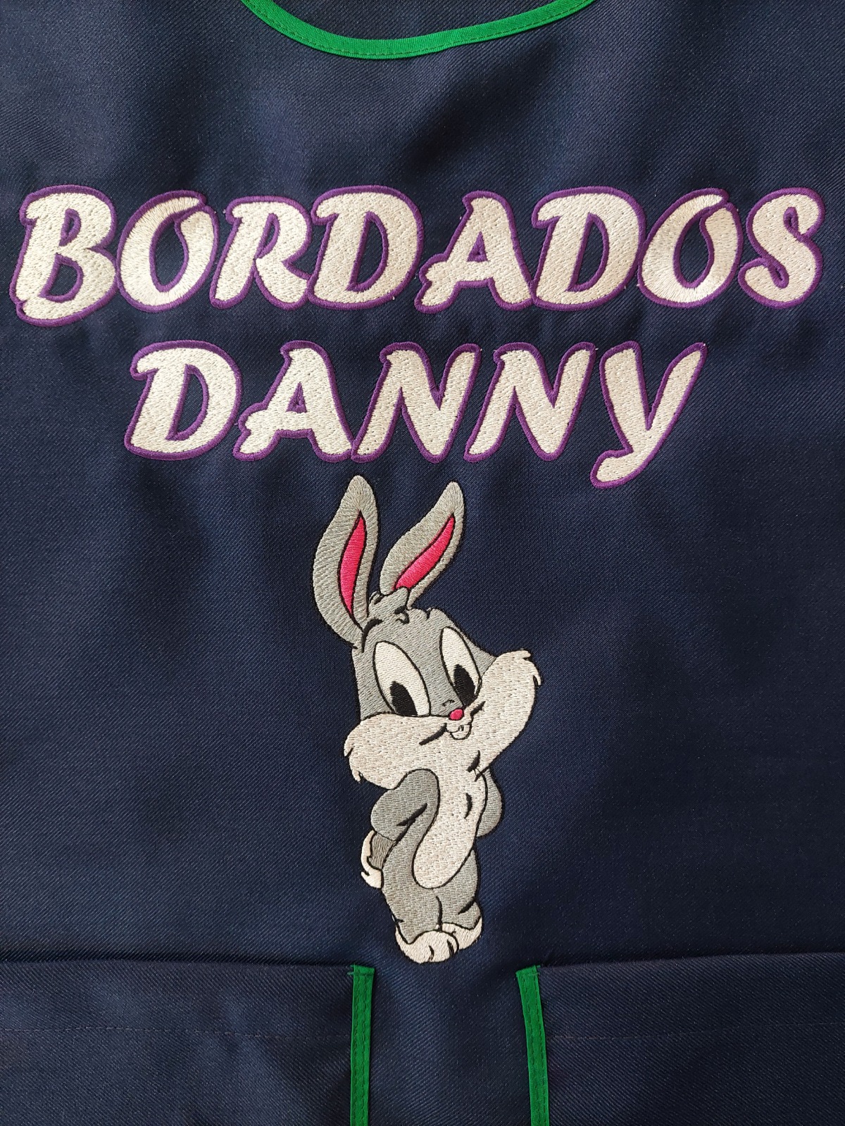 Mandil azul con texto Bordados Danny y personaje bordado