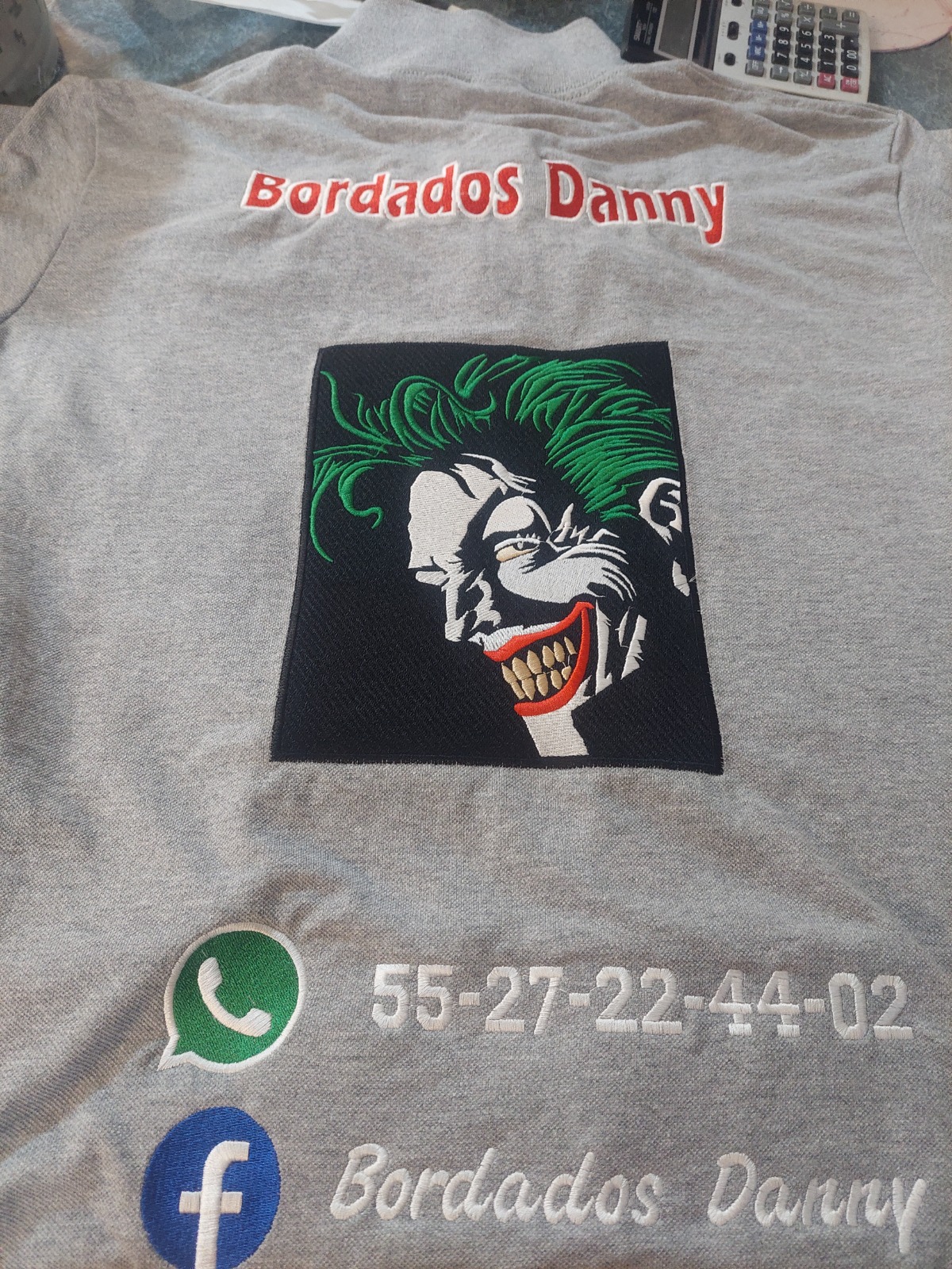 Playera azul con logo Bordados Danny y datos bordados